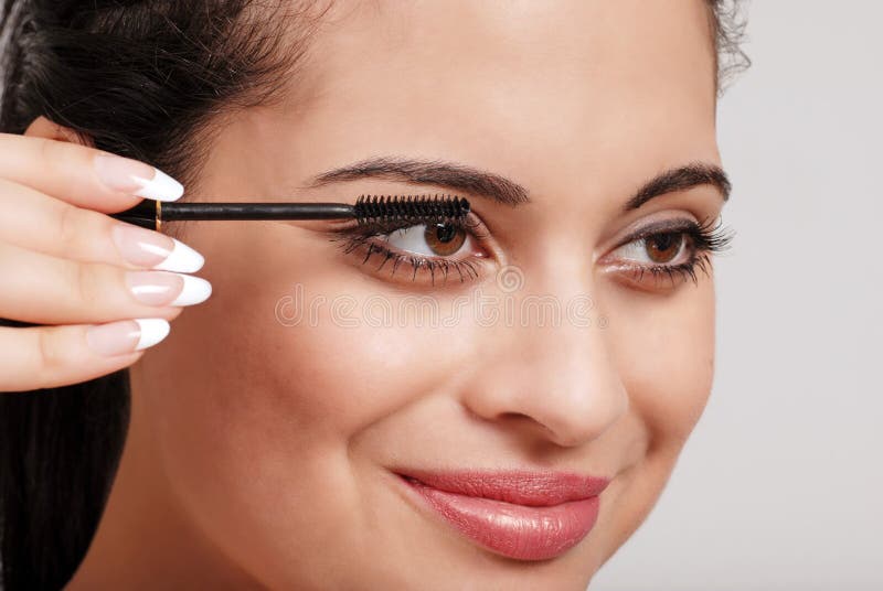 Headshot woman applying mascara royalty free stock image