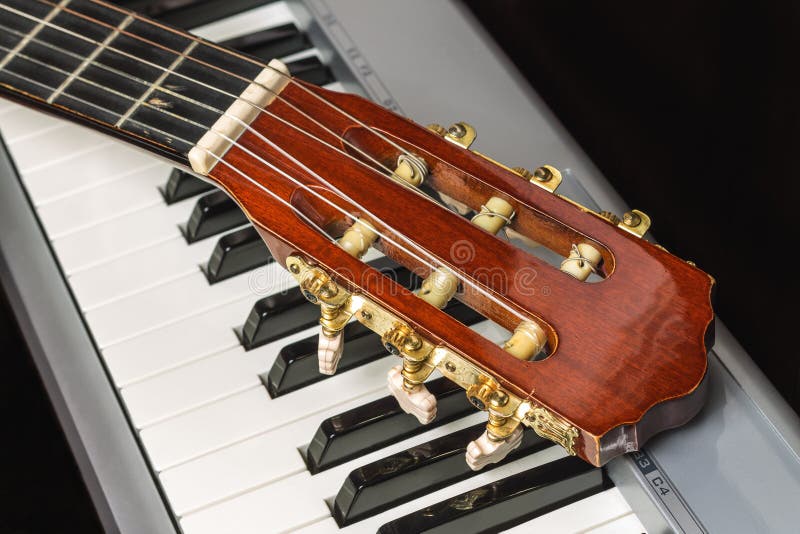 Headstock da guitarra no teclado de piano fotografia de stock royalty free Headstock da guitarra no teclado de piano fotografia de stock royalty free