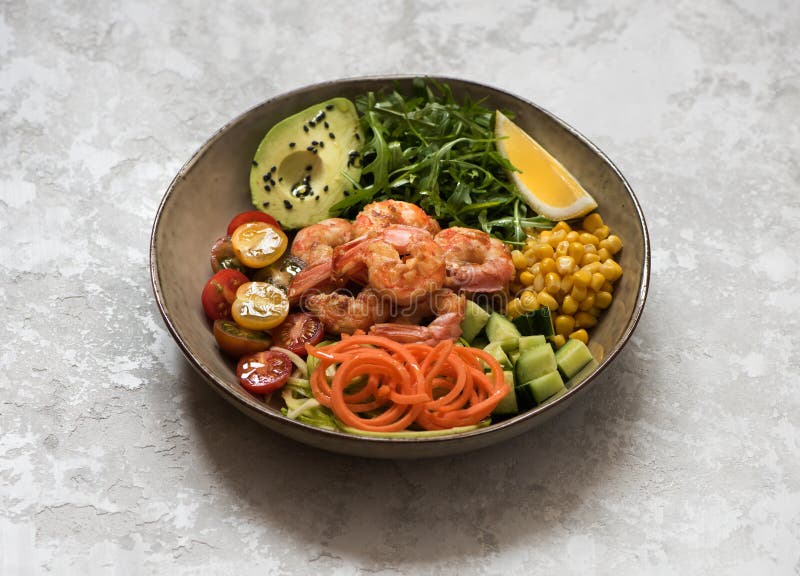 Healhty lunch bowl salad with grilled shrimp, fresh vegetables and herbs.