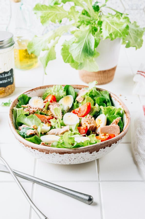 Healhty tuna salad with tomato, quail eggs, lettuce and salad dressing with olive oil, lemon juice and grain mustard. stock image Healhty tuna salad with tomato, quail eggs, lettuce and salad dressing with olive oil, lemon juice and grain mustard. stock image