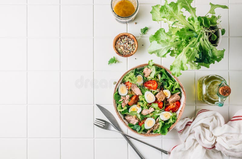 Healhty tuna salad with tomato, quail eggs, lettuce and salad dressing with olive oil, lemon juice and grain mustard. stock photo Healhty tuna salad with tomato, quail eggs, lettuce and salad dressing with olive oil, lemon juice and grain mustard. stock photo