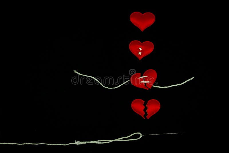 Healing broken heart concept  red heart is sewn with white thread with needle on black background