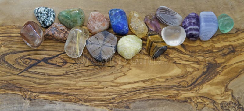 Healing crystals on olive wood background