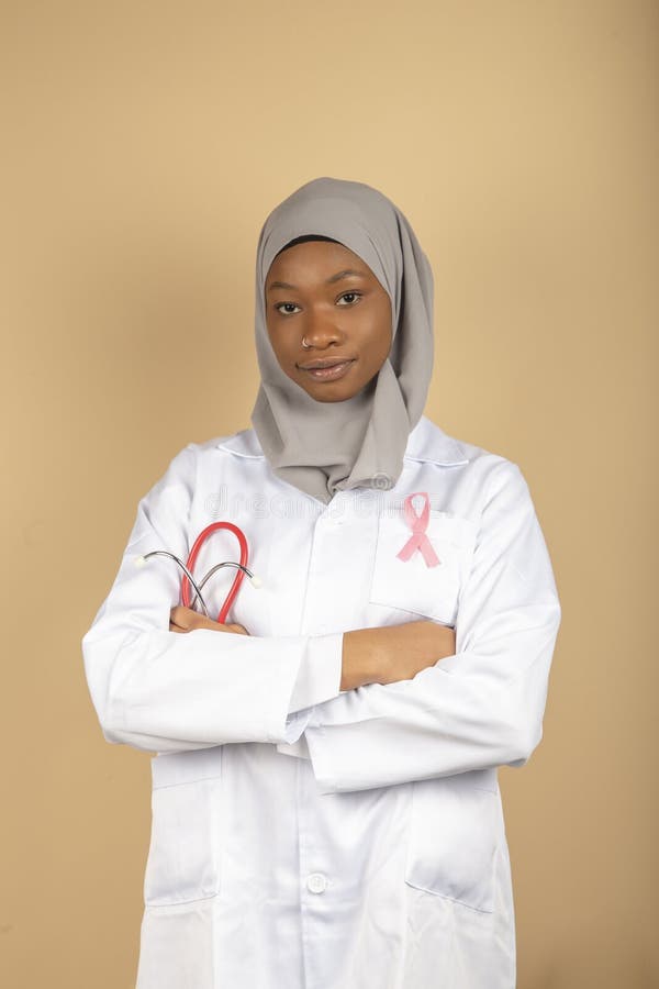 Health care for Muslim women. Portrait of an African-American female doctor wearing a bandana and white coat posing with her arms