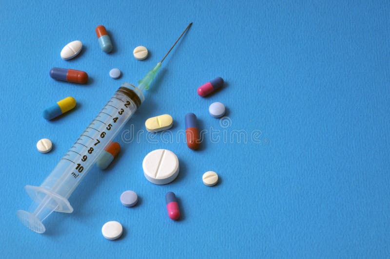 Health concept with syringe and drugs set in bulk on blue background. Health concept with syringe and drugs set in bulk on blue background