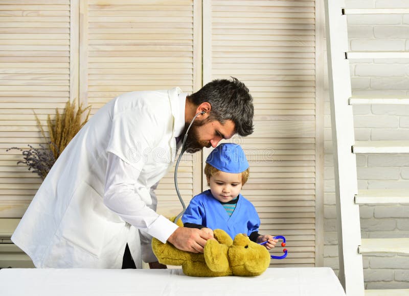Healthcare and childhood concept. Man and boy hold stethoscope