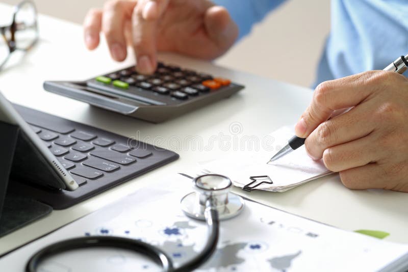 Healthcare costs and fees concept. Hand of smart doctor used a calculator for medical costs in modern hospital