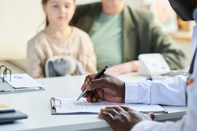 Signing Medical Form in Clinic with Patient in Background royalty free stock photo