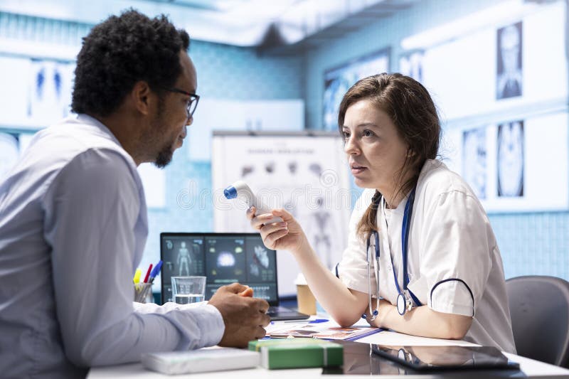 Healthcare specialist using thermometer to check fever measurements stock photos