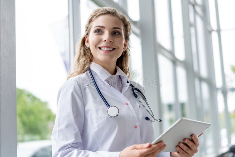Healthcare, technology and medicine concept - smiling female doctor with stethoscope taking notes at tablet pc computer. Healthcare, technology and medicine royalty free stock images Healthcare, technology and medicine concept - smiling female doctor with stethoscope taking notes at tablet pc computer. Healthcare, technology and medicine royalty free stock images