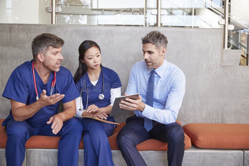 Healthcare workers in discussion using a tablet computer stock photos Healthcare workers in discussion using a tablet computer stock photos