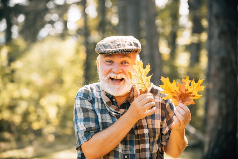 Healthy active senior man holding a. Portrait of a senior autumn man outdoors. Elderly man smiling outdoors in nature