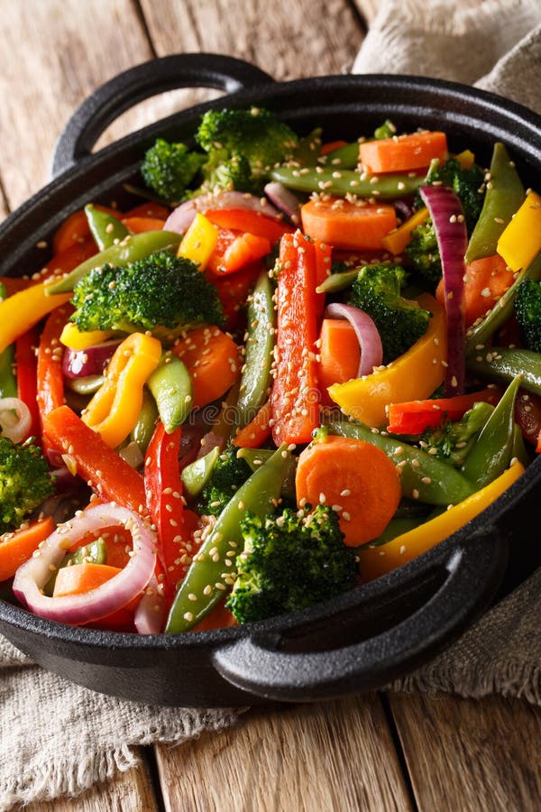 Healthy Asian food stir fry of vegetables with sesame close-up in a bowl, vertical royalty free stock image Healthy Asian food stir fry of vegetables with sesame close-up in a bowl, vertical royalty free stock image
