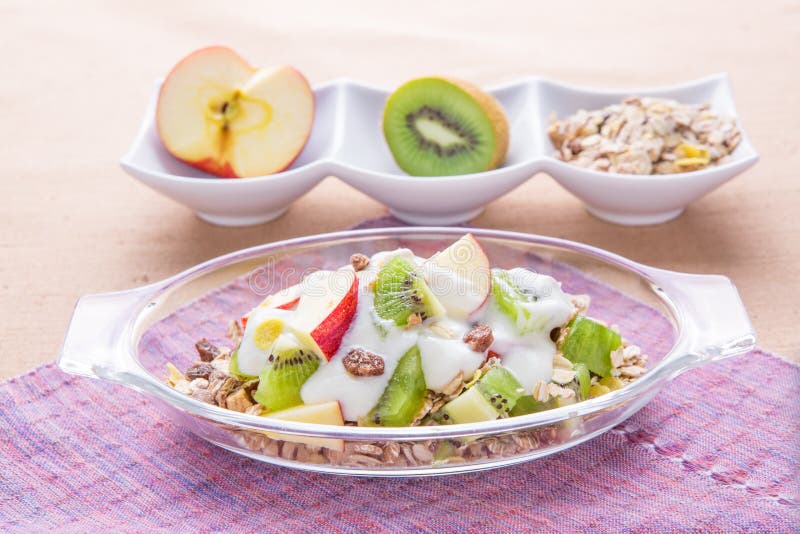 Healthy bowl of muesli, apple, fruit, nuts and milk for a nutrit
