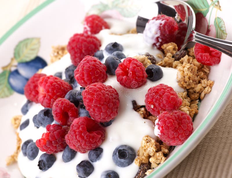 Gesundes Frühstück von mueseli, Joghurt, Himbeeren und Heidelbeeren.