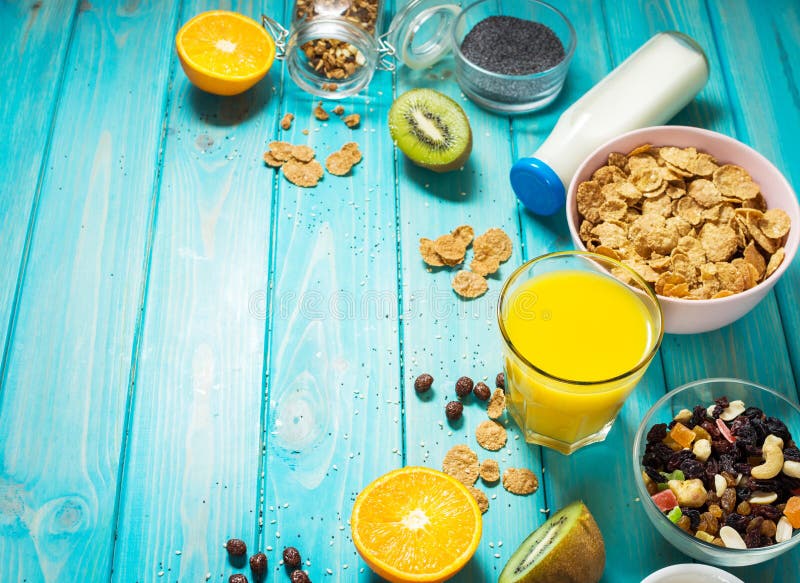 Healthy breakfast with bowl of cereal, orange juice, granola, milk, jam and fruits on blue wood background. Balanced diet. royalty free stock images Healthy breakfast with bowl of cereal, orange juice, granola, milk, jam and fruits on blue wood background. Balanced diet. royalty free stock images