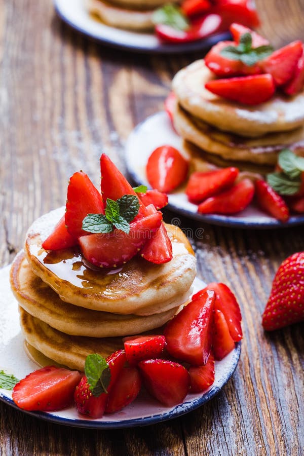 Breakfast or brunch, pancakes with fresh summer strawberries, powdered sugar, honey royalty free stock photography Breakfast or brunch, pancakes with fresh summer strawberries, powdered sugar, honey royalty free stock photography