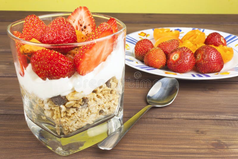 Healthy breakfast with fruit. Homemade yogurt, oatmeal with strawberries, apricots and chocolate.