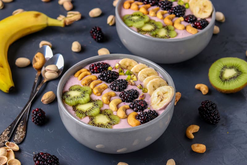 Healthy breakfast smoothie bowl with blackberries, bananas, cashews, kiwi and pistachios on a dark background, horizontal photo stock photo Healthy breakfast smoothie bowl with blackberries, bananas, cashews, kiwi and pistachios on a dark background, horizontal photo stock photo