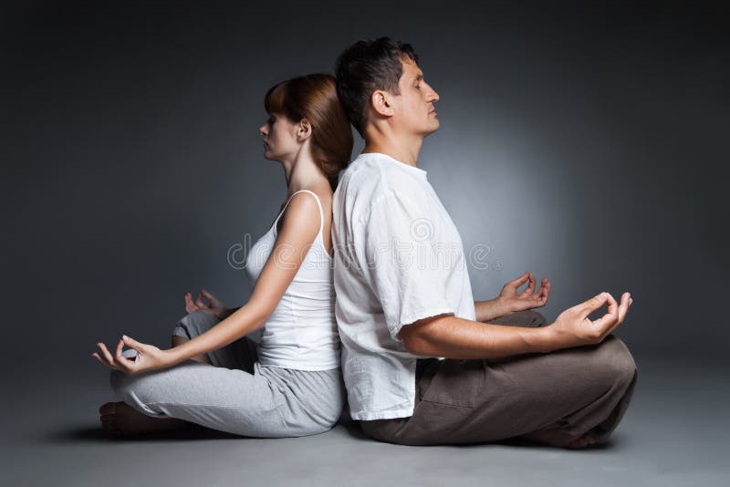 Healthy couple in yoga position on dark