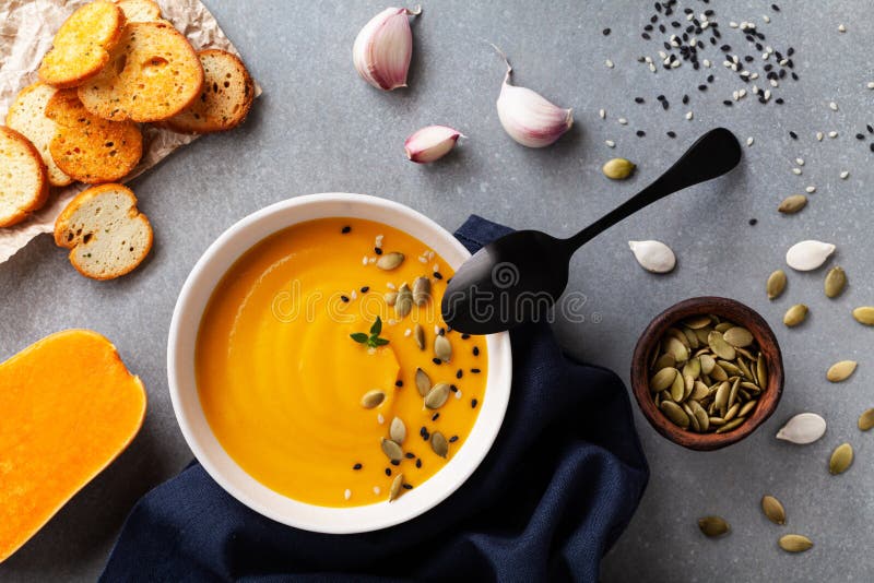 Healthy and delicious autumn pumpkin cream soup in bowl served with seeds and crouton on stone table top view royalty free stock images Healthy and delicious autumn pumpkin cream soup in bowl served with seeds and crouton on stone table top view royalty free stock images