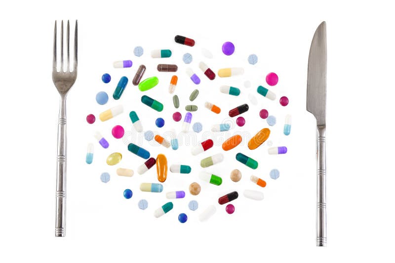 Healthy eating concept, Medication with different types and colours. Tablets and pils. Silver fork and knife stock photo Healthy eating concept, Medication with different types and colours. Tablets and pils. Silver fork and knife stock photo