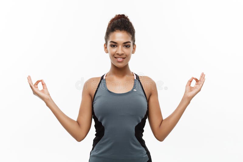 Healthy and Fitness concept - Beautiful American African lady in fitness clothing doing yoga and meditation. Isolated on. White background royalty free stock photo Healthy and Fitness concept - Beautiful American African lady in fitness clothing doing yoga and meditation. Isolated on. White background royalty free stock photo