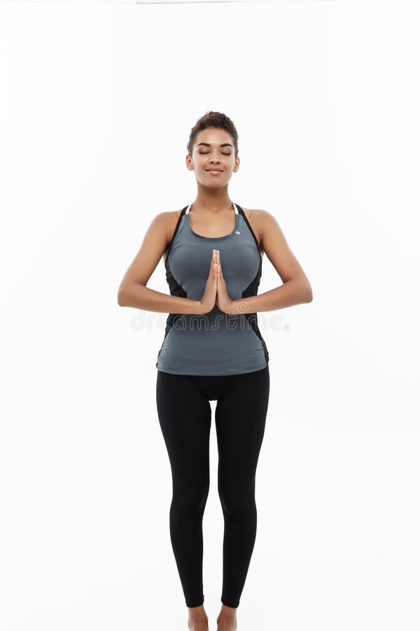 Healthy and Fitness concept - Beautiful American African lady in fitness clothing doing yoga and meditation. Isolated on. White background stock photography Healthy and Fitness concept - Beautiful American African lady in fitness clothing doing yoga and meditation. Isolated on. White background stock photography