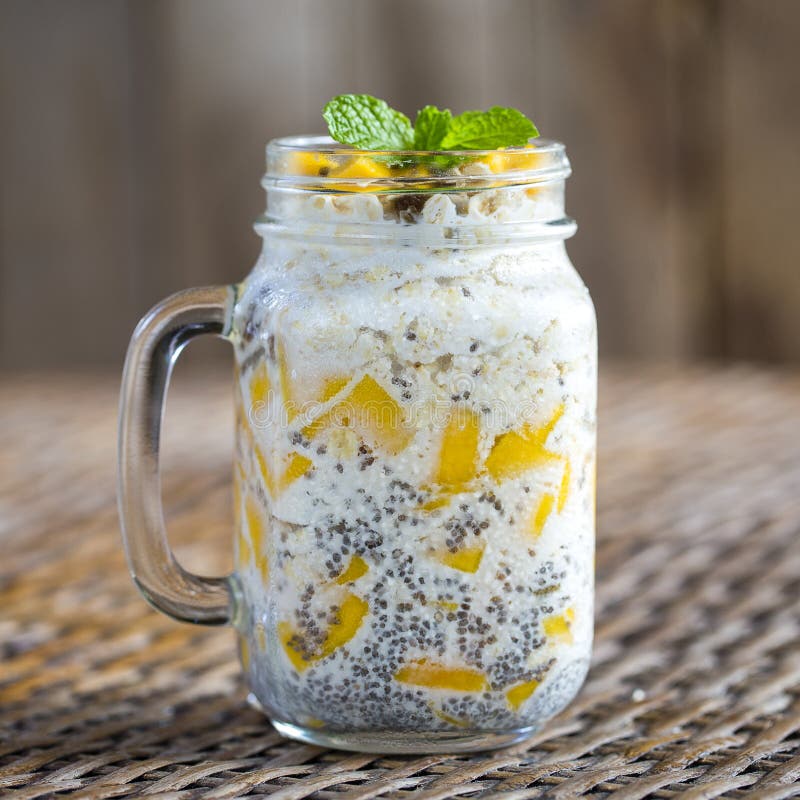 Healthy food, chia seed pudding with mango, oat flakes, coconut milk and muesli, vitamin breakfast in glass mug. Morning in Thaila