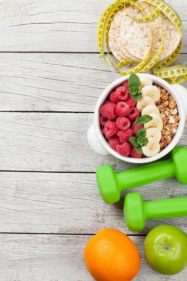 Healthy food and fitness concept. Breakfast cereal, fruits, nuts and sport equipment. Top view flat lay with copy space for your text stock photography Healthy food and fitness concept. Breakfast cereal, fruits, nuts and sport equipment. Top view flat lay with copy space for your text stock photography