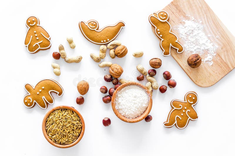 Healthy food for sportsman. Cookies in shape of yoga asanas near nuts on white background top view. Health, holiday.