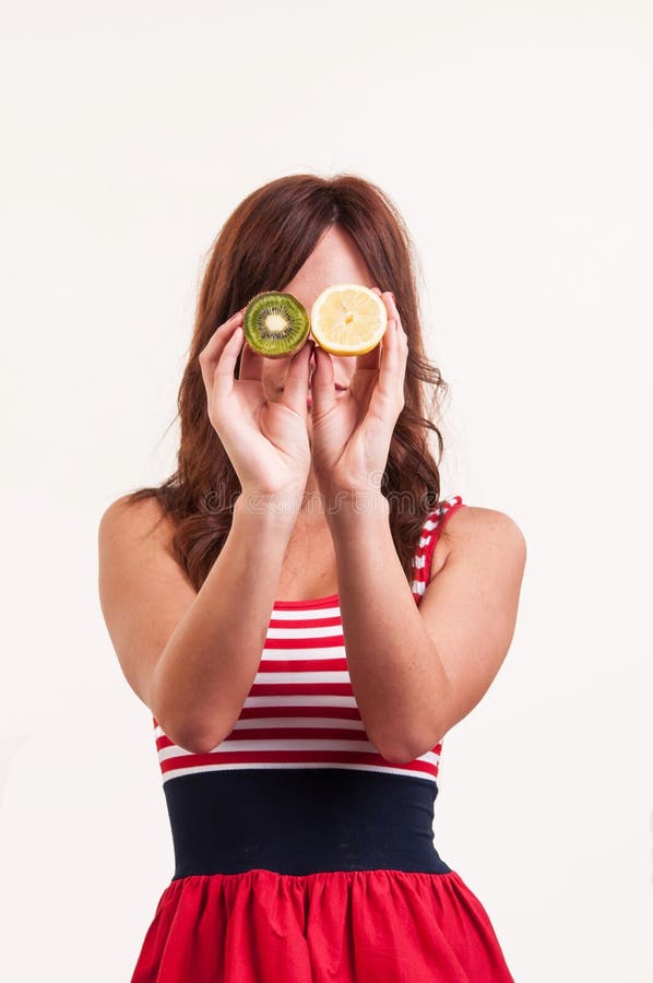 Healthy fruit, funny woman holding kiwi and lemon fruit for her e stock photos Healthy fruit, funny woman holding kiwi and lemon fruit for her e stock photos