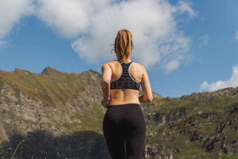 Young woman running in the mountains during a sunny day royalty free stock image Young woman running in the mountains during a sunny day royalty free stock image