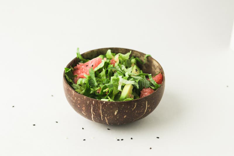 Healthy green vegan salad in coconut bowl