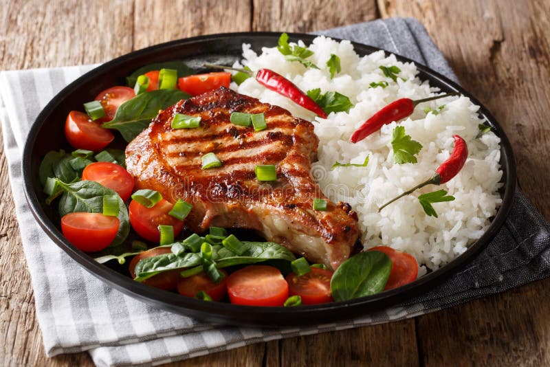 Healthy Grilled Pork Steak with Rice and Fresh Vegetables Close-up on a