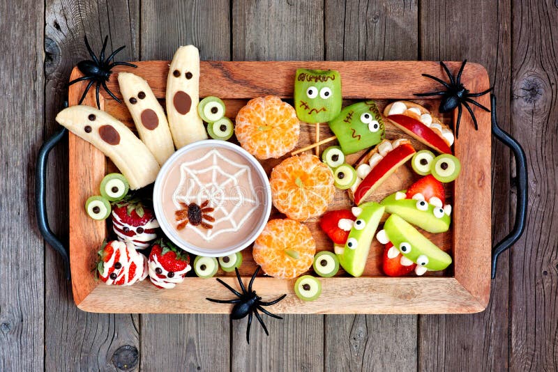 Healthy Halloween fruit snacks. Tray of fun, spooky treats. Top view over a rustic wood background. Healthy Halloween fruit snacks. Tray of fun, spooky treats. Top view over a rustic wood background