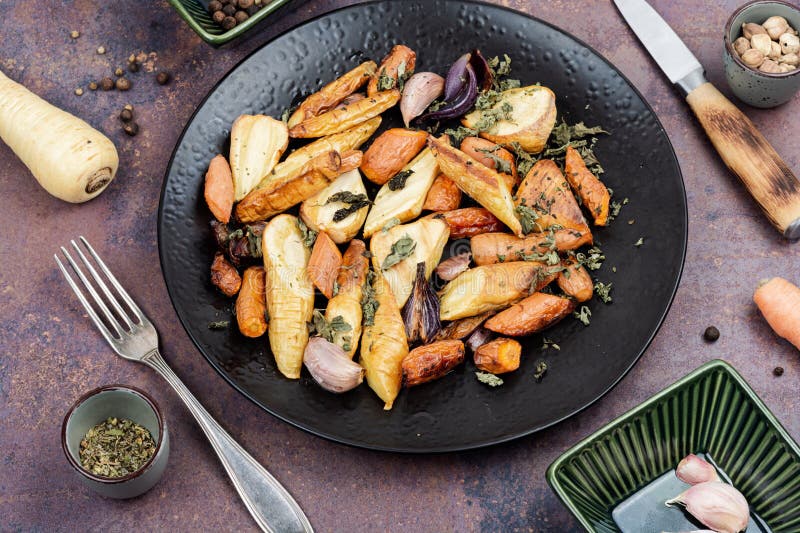 Baked sliced parsnip root and carrots stock photography