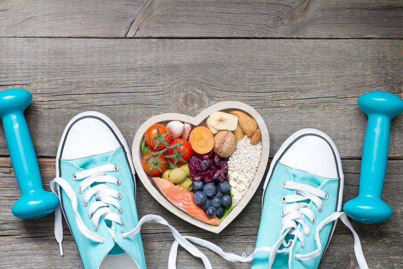 Zdravý životný štýl koncept s potravinami v srdci športové a fitness doplnky na drevené dosky.