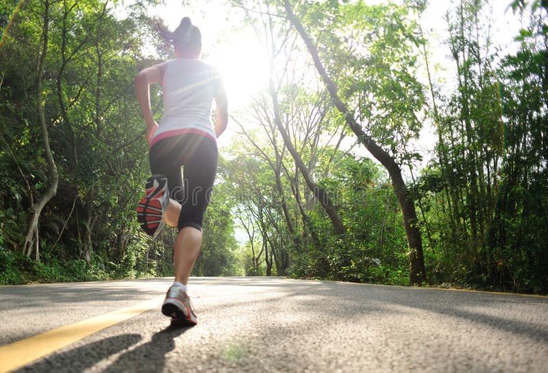 Stile di vita sano sport fitness donna in esecuzione alla strada forestale.