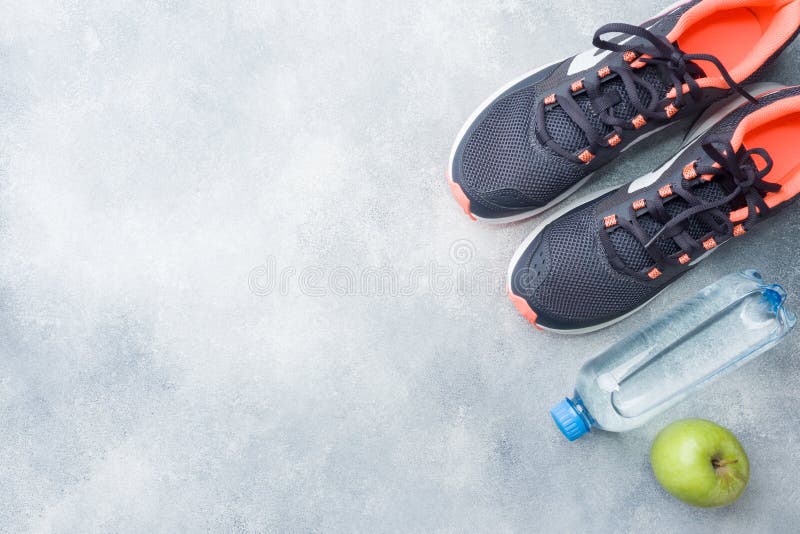 Healthy lifestyle, food and water, athlete`s equipment on grey background. Flat lay. Top view with copy space. stock image Healthy lifestyle, food and water, athlete`s equipment on grey background. Flat lay. Top view with copy space. stock image