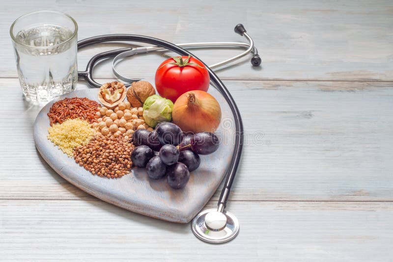 Healthy lifestyle and healthcare concept with food, heart and stethoscope