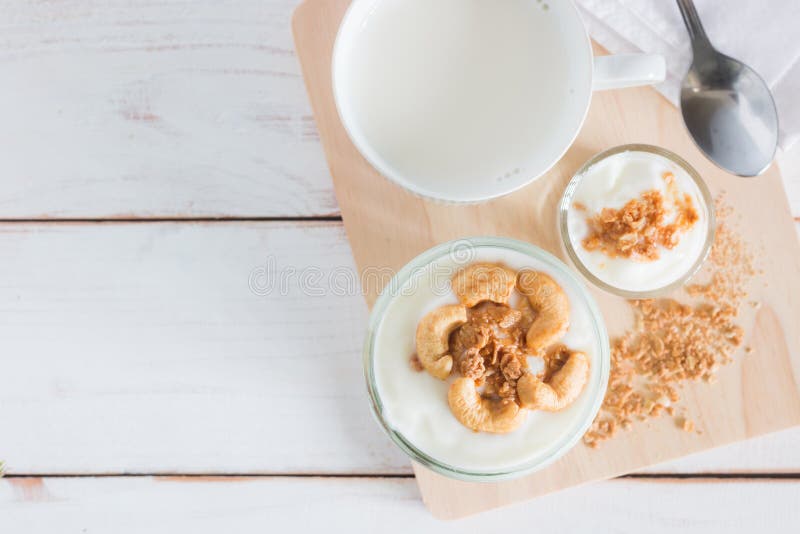 Healthy meal made of granola in glass, Yogurt and cornflakes Decorate food with Cashew Nut with hot milk
