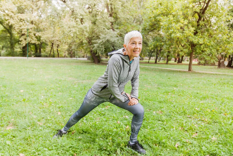 Healthy Middle Aged Woman Stretching Exercise In Nature stock image Healthy Middle Aged Woman Stretching Exercise In Nature stock image