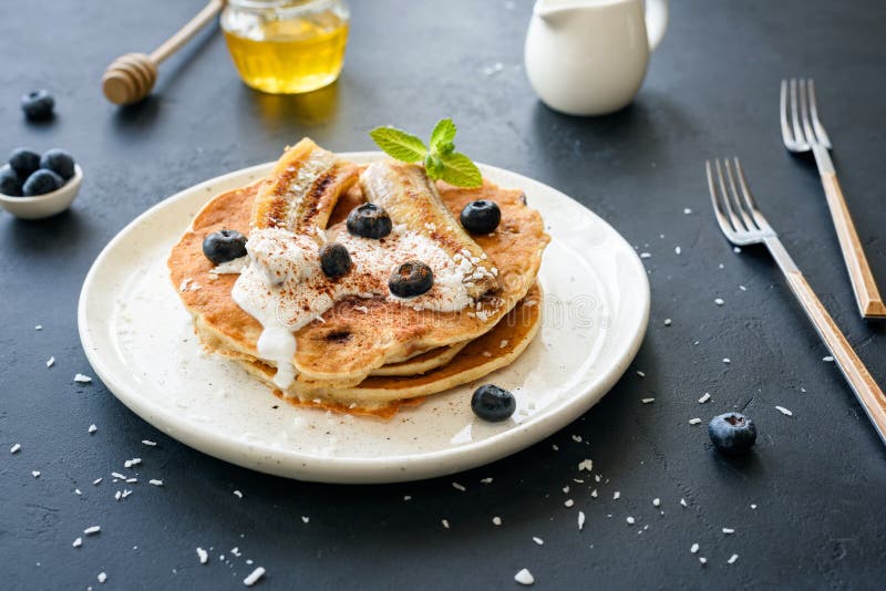 Healthy oat pancakes with banana, blueberries and yogurt