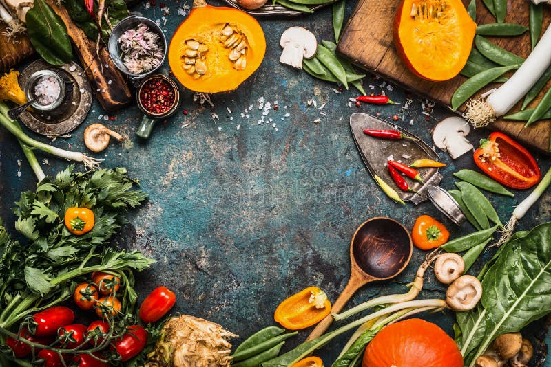 Healthy and organic harvest vegetables and ingredients: pumpkin, greens, tomatoes,kale,leek,chard,celery on rustic kitchen table b