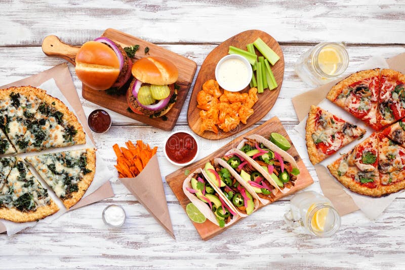 Healthy plant based fast food table scene. Top view on a white wood background.