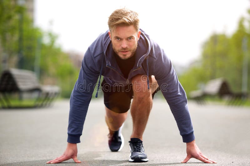 Portrait of healthy runner in starting position outside. Determined jogger stock images, royalty-free photos and pictures