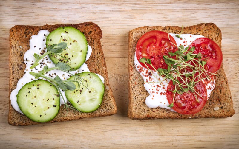 Healthy sandwiches with cream cheese, pea and linen microgreens, cucumber slices and spices on cutting board. Healthy eating, diet vegan food. Top view