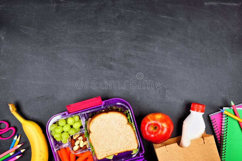 Top down view of school supplies and lunch on a light background