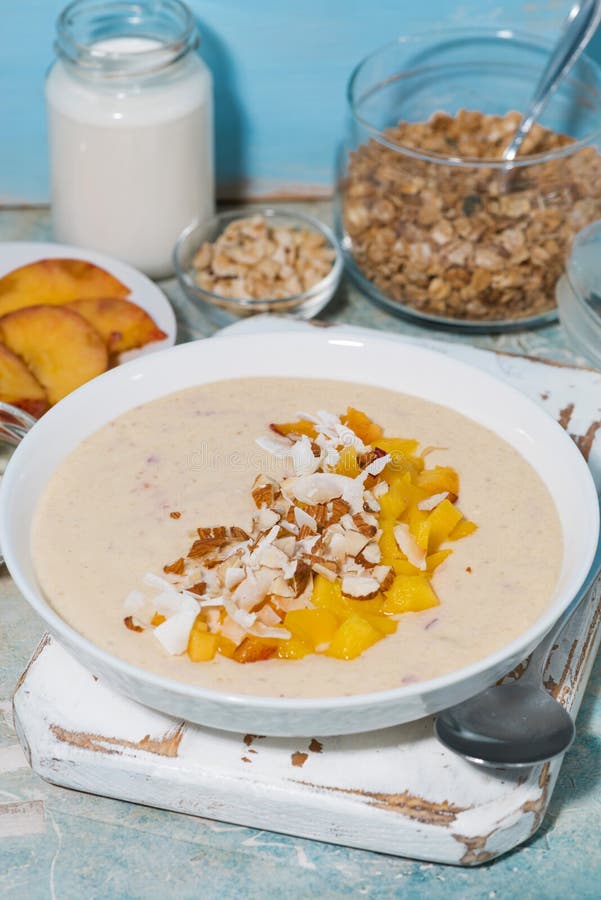 Healthy Smoothie Bowl with Mango, Coconut and Nuts for Breakfast
